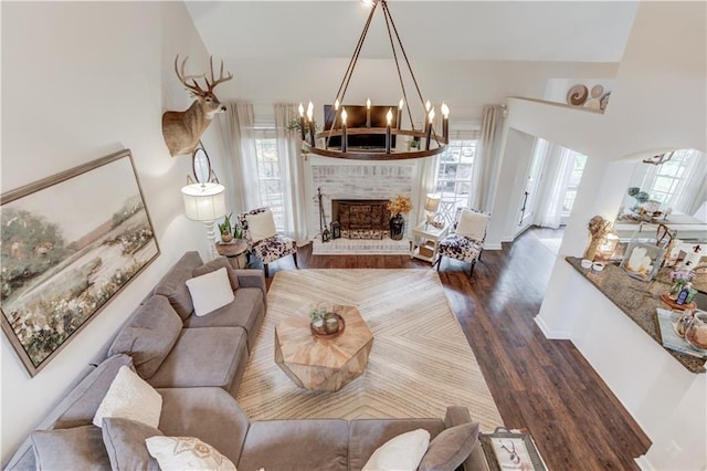 living room with dark wood-type flooring, a fireplace, and a healthy amount of sunlight