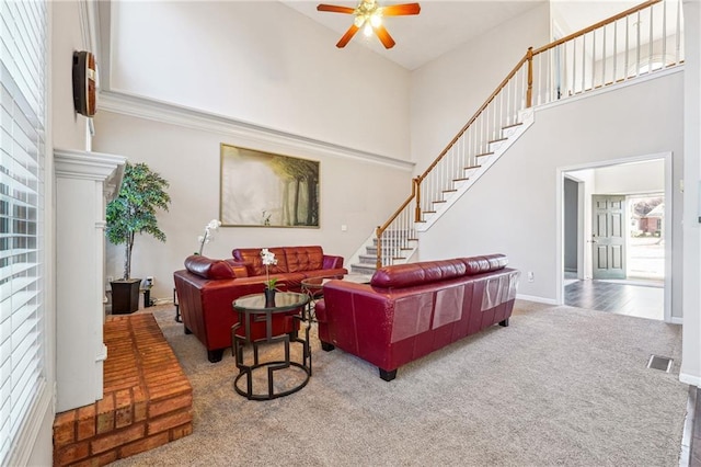 living room with carpet flooring, ceiling fan, and a high ceiling