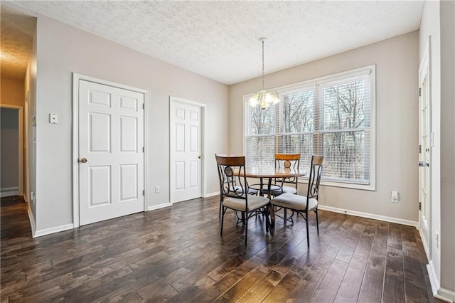 dining space with dark wood-type flooring, a chandelier, and a textured ceiling