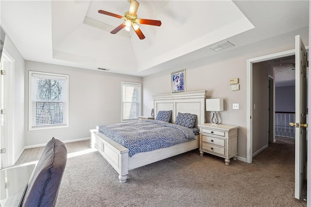 bedroom with ceiling fan, carpet floors, and a tray ceiling