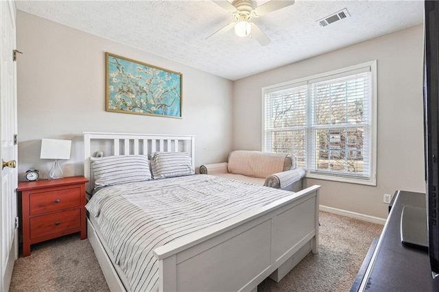 bedroom featuring ceiling fan, light colored carpet, and a textured ceiling