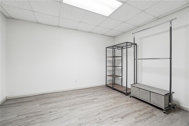 spare room featuring a drop ceiling and light wood-type flooring