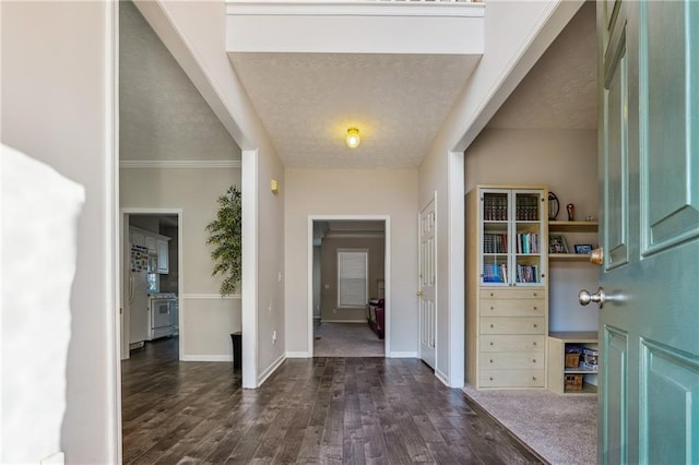 foyer entrance featuring dark hardwood / wood-style floors, crown molding, and a textured ceiling