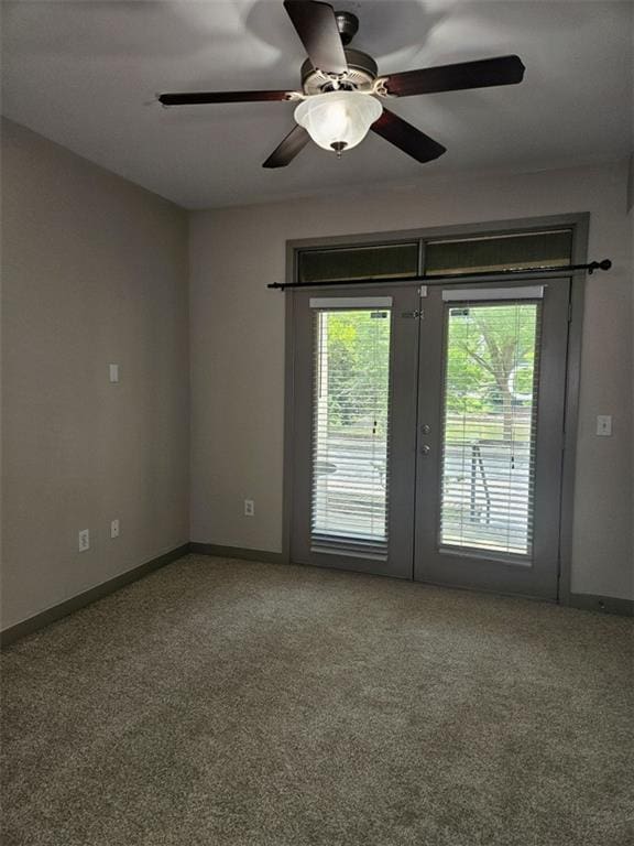 carpeted empty room featuring a ceiling fan, french doors, baseboards, and a wealth of natural light