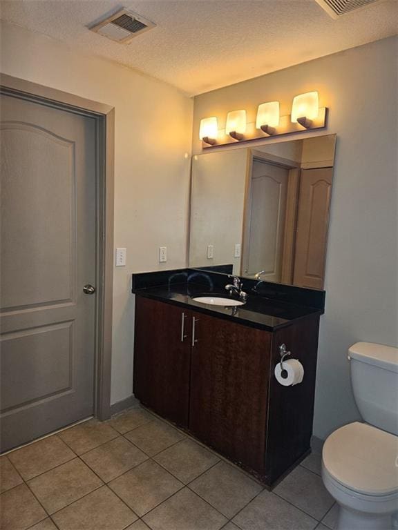 bathroom with vanity, visible vents, tile patterned flooring, a textured ceiling, and toilet