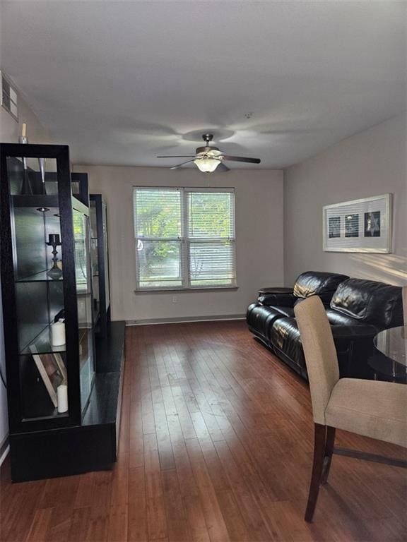 living area featuring visible vents, dark wood finished floors, and a ceiling fan