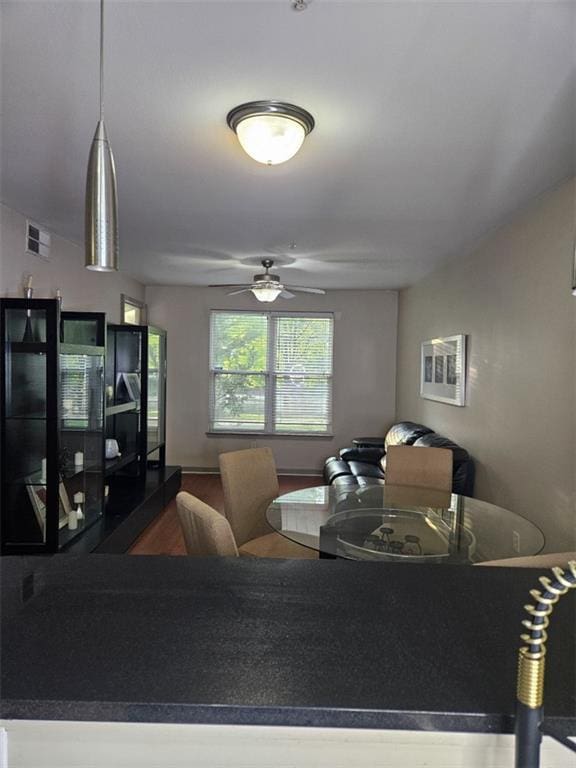 living room featuring visible vents, wood finished floors, and a ceiling fan