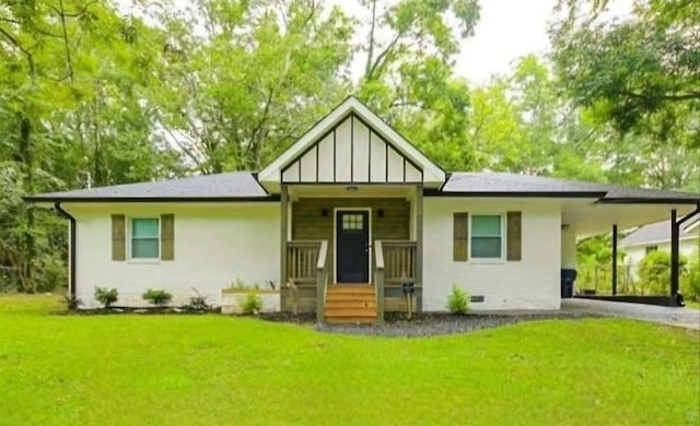 view of front of property with aphalt driveway, crawl space, a carport, a front lawn, and board and batten siding