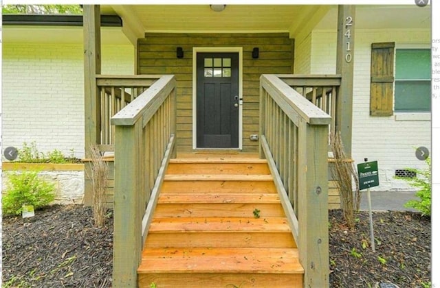 doorway to property featuring brick siding