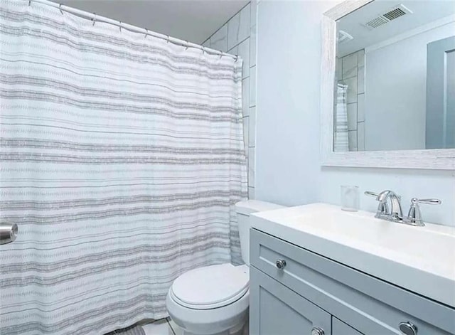 full bathroom featuring toilet, vanity, and visible vents