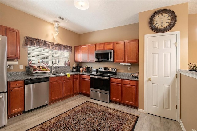 7324 Bridlewood Ct, Jonesboro, GA 30236 - kitchen featuring appliances with stainless steel finishes, light wood-style floors, and brown cabinets