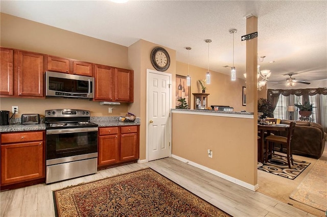 7324 Bridlewood Ct, Jonesboro, GA 30236 - kitchen with stainless steel appliances, light wood-type flooring, brown cabinets, open floor plan, and ceiling fan