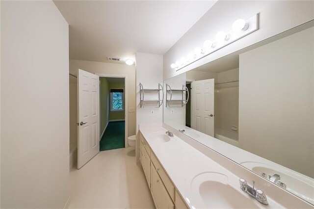 bathroom featuring a sink, toilet, double vanity, and visible vents