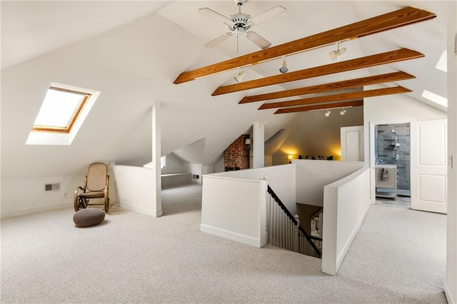 additional living space featuring vaulted ceiling with skylight and light carpet