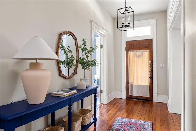 foyer entrance with dark wood-type flooring and a chandelier