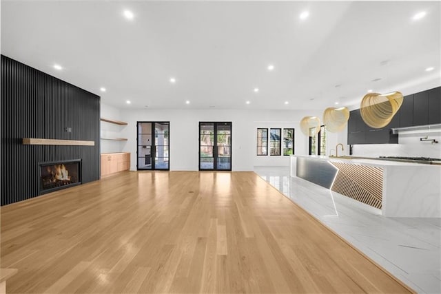 stairway featuring baseboards, french doors, wood finished floors, and recessed lighting