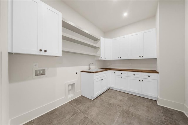 kitchen featuring high end fridge, a sink, marble finish floor, backsplash, and light stone countertops