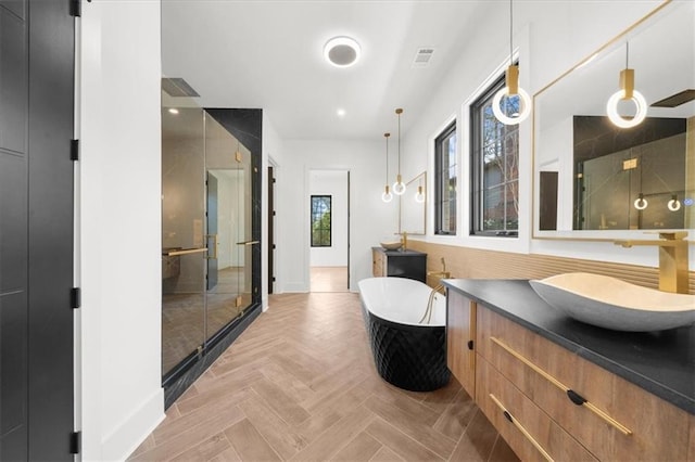 full bathroom with visible vents, vanity, baseboards, a soaking tub, and a stall shower