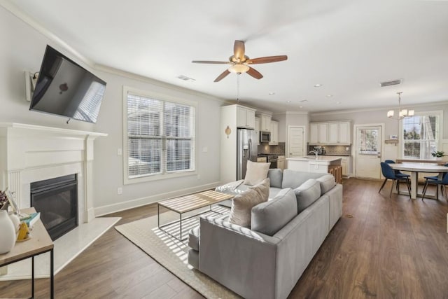 living room featuring ornamental molding, sink, and dark hardwood / wood-style floors