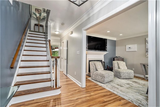 stairs with ornamental molding and hardwood / wood-style flooring