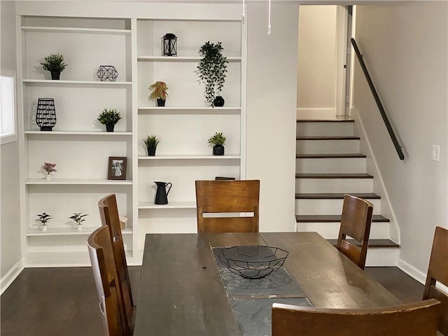 dining room with dark hardwood / wood-style floors and built in features