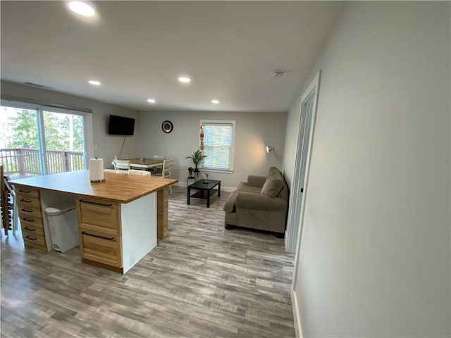 kitchen featuring plenty of natural light, light brown cabinetry, a kitchen island, and light wood-type flooring