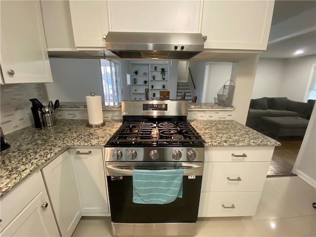 kitchen with white cabinets, light stone countertops, exhaust hood, and stainless steel gas range