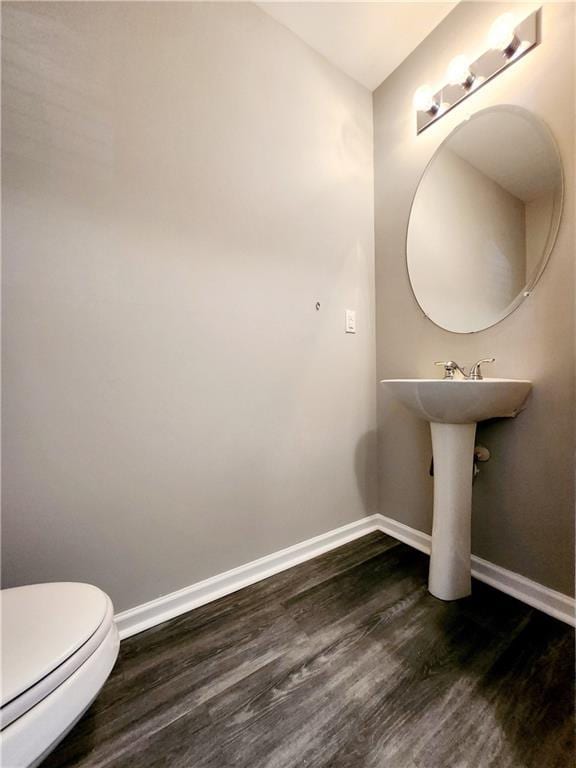 bathroom featuring toilet, baseboards, and wood finished floors