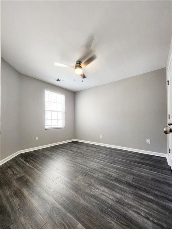 unfurnished room with a ceiling fan, visible vents, baseboards, and dark wood-style flooring