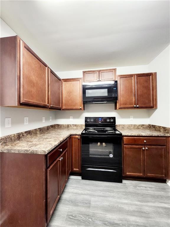 kitchen featuring light wood-style flooring and black appliances