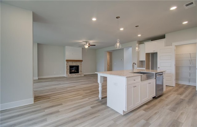 kitchen featuring white cabinetry, sink, dishwasher, ceiling fan, and a kitchen island with sink