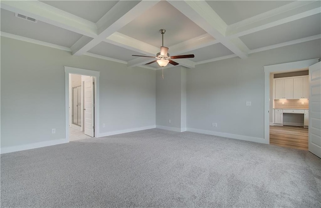 interior space with light carpet, beam ceiling, and ensuite bath