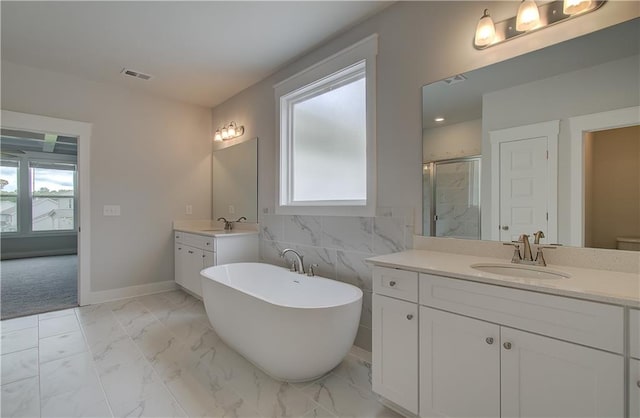 bathroom featuring vanity, separate shower and tub, and tile walls