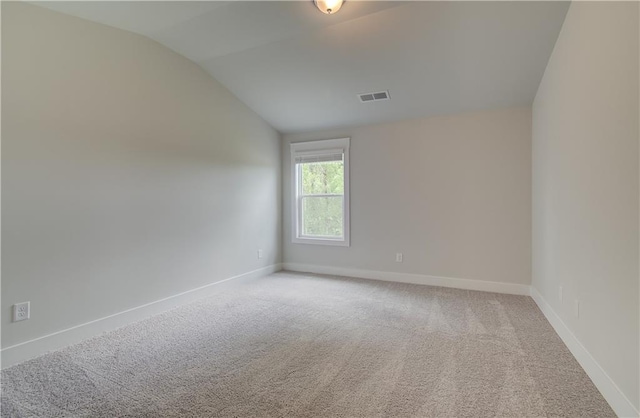 carpeted spare room with lofted ceiling