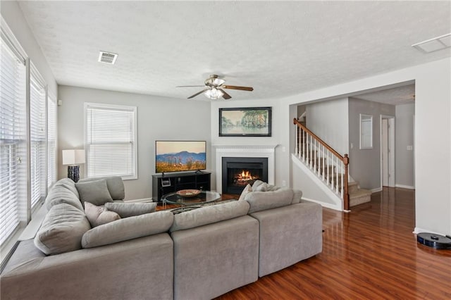 3698 Roseman Lndg, Cumming, GA 30040 - living room with a ceiling fan, wood finished floors, stairway, a warm lit fireplace, and a textured ceiling