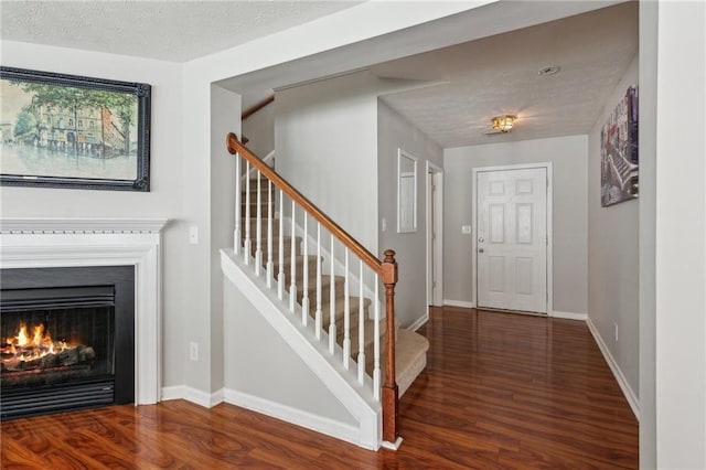 3698 Roseman Lndg, Cumming, GA 30040 - entryway with wood finished floors, stairway, baseboards, and a warm lit fireplace