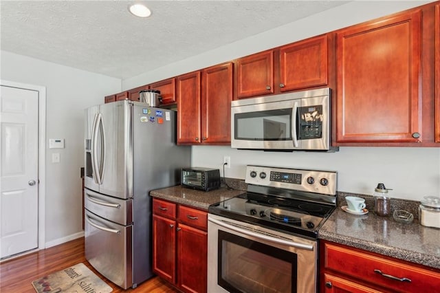 3698 Roseman Lndg, Cumming, GA 30040 - kitchen with stainless steel appliances, dark brown cabinets, wood finished floors, a textured ceiling, and baseboards