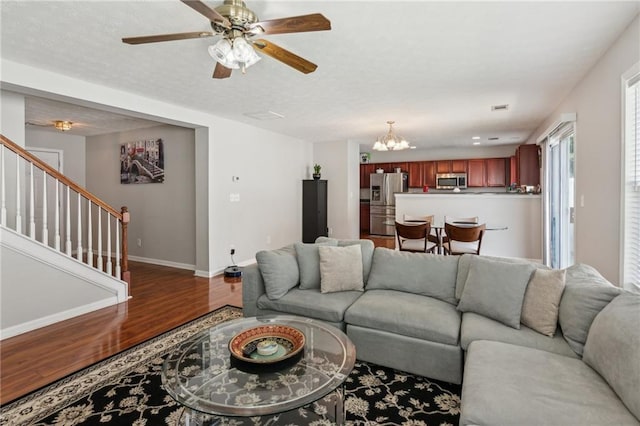 3698 Roseman Lndg, Cumming, GA 30040 - living area featuring wood finished floors, a chandelier, baseboards, ceiling fan, and stairway