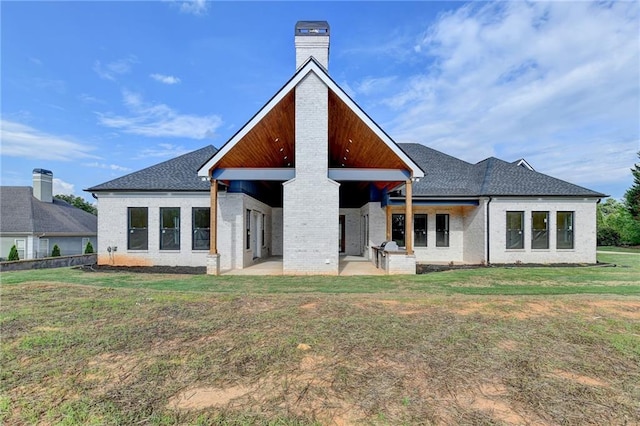 back of house featuring a patio area and a lawn