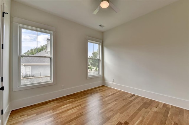 empty room featuring ceiling fan, light hardwood / wood-style floors, and a healthy amount of sunlight