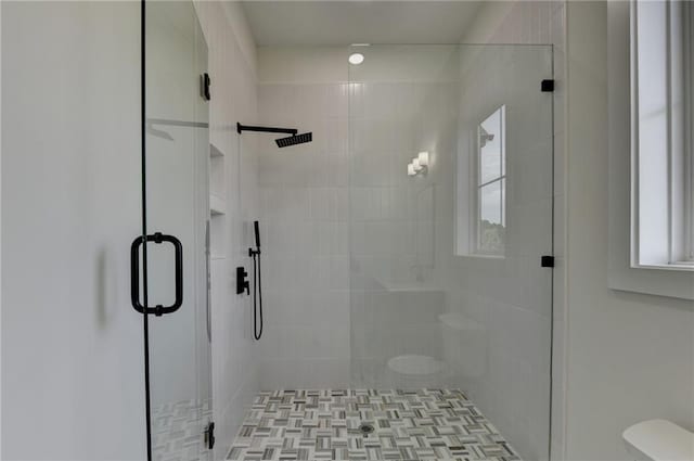 bathroom with toilet and a shower with shower door