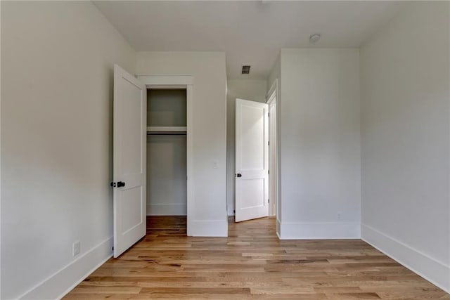 unfurnished bedroom featuring a closet and light wood-type flooring