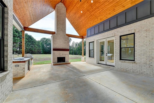 view of patio / terrace with an outdoor brick fireplace and french doors