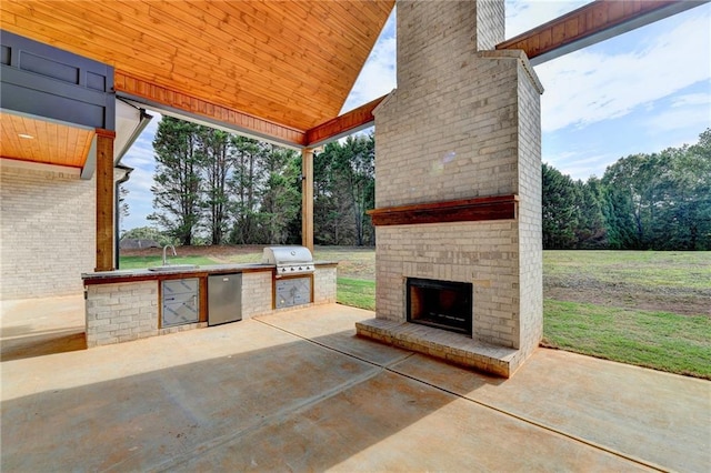 view of patio / terrace featuring an outdoor brick fireplace, sink, grilling area, and an outdoor kitchen