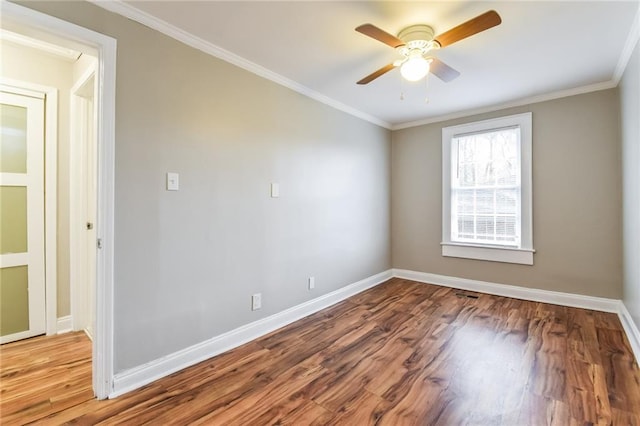 empty room featuring wood-type flooring and ornamental molding