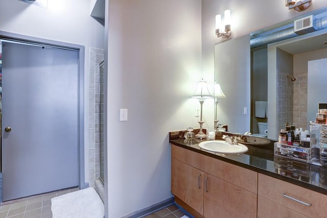 bathroom with vanity, toilet, tile patterned floors, and walk in shower