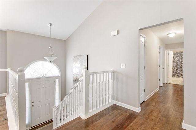 entryway with hardwood / wood-style floors and high vaulted ceiling