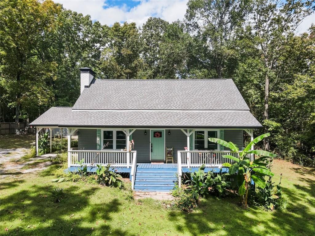 farmhouse featuring a front lawn and covered porch