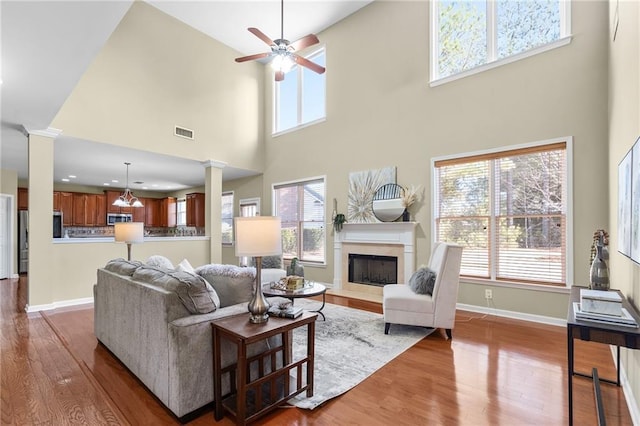 living room with plenty of natural light, light hardwood / wood-style flooring, and ornate columns