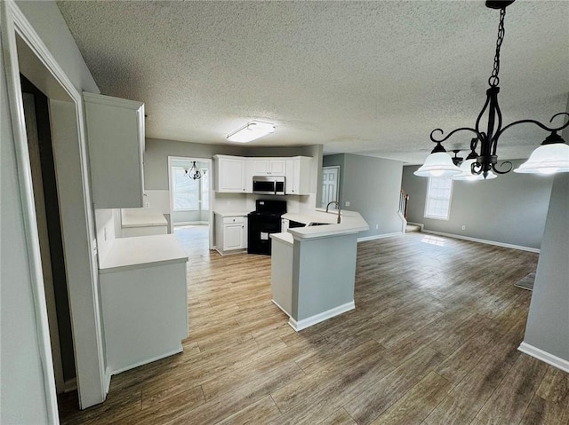 108 Northcutt Station Pl, Acworth, GA 30101 - kitchen featuring a chandelier, black range with electric stovetop, stainless steel microwave, wood finished floors, and a textured ceiling